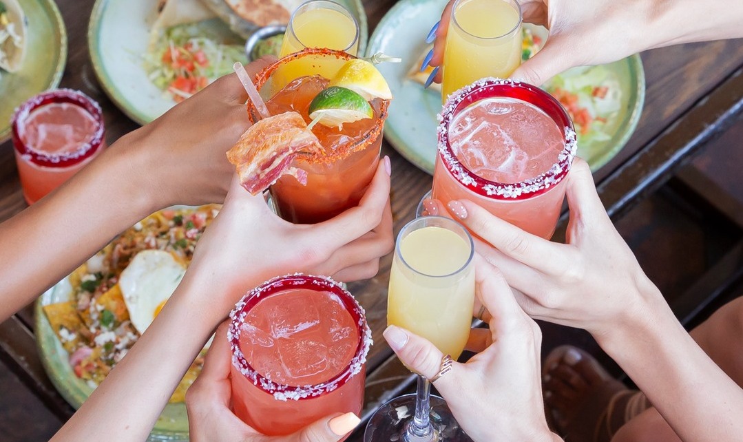A group of people toasting with various drinks in Casa Amigos