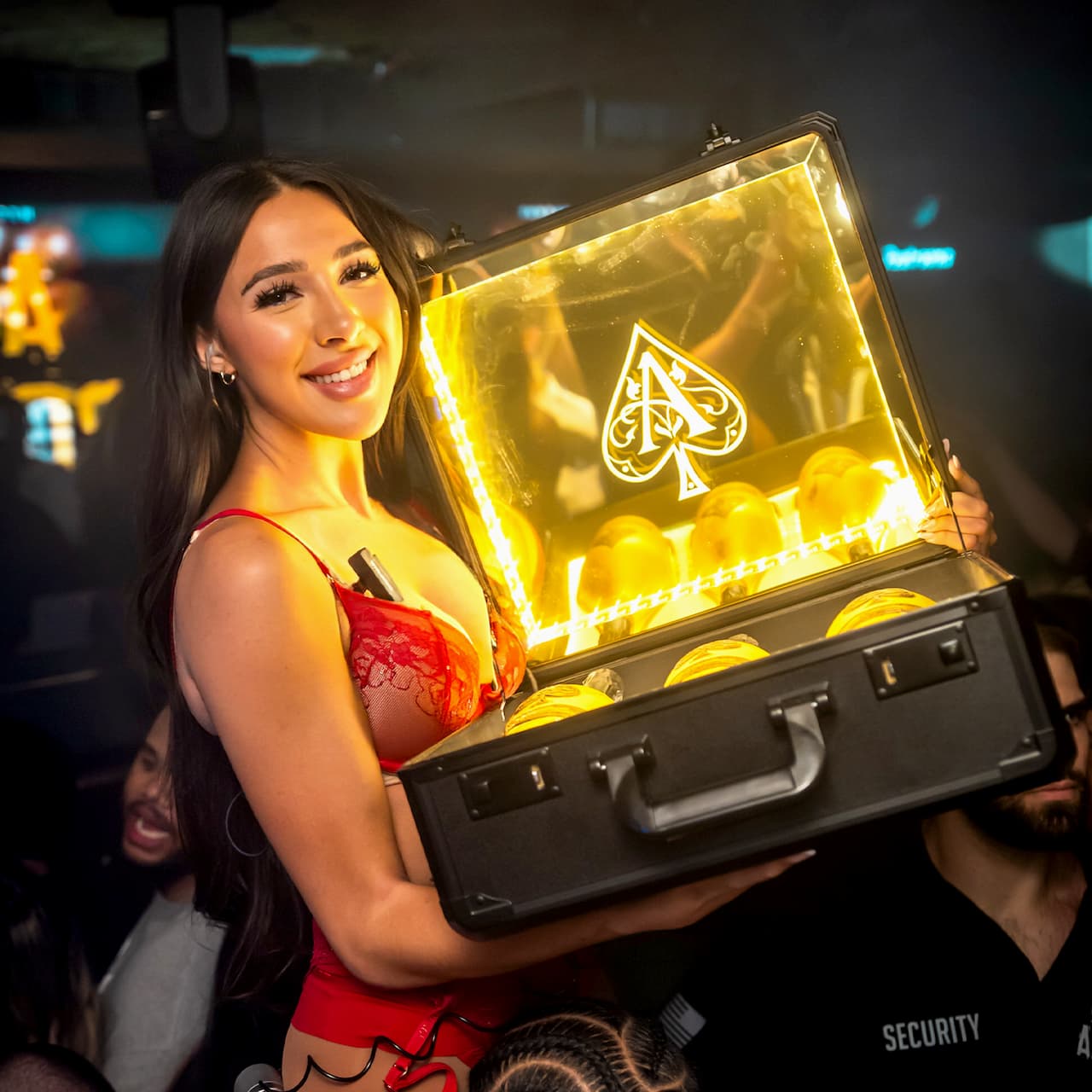 girl holding a case with three liquor bottles